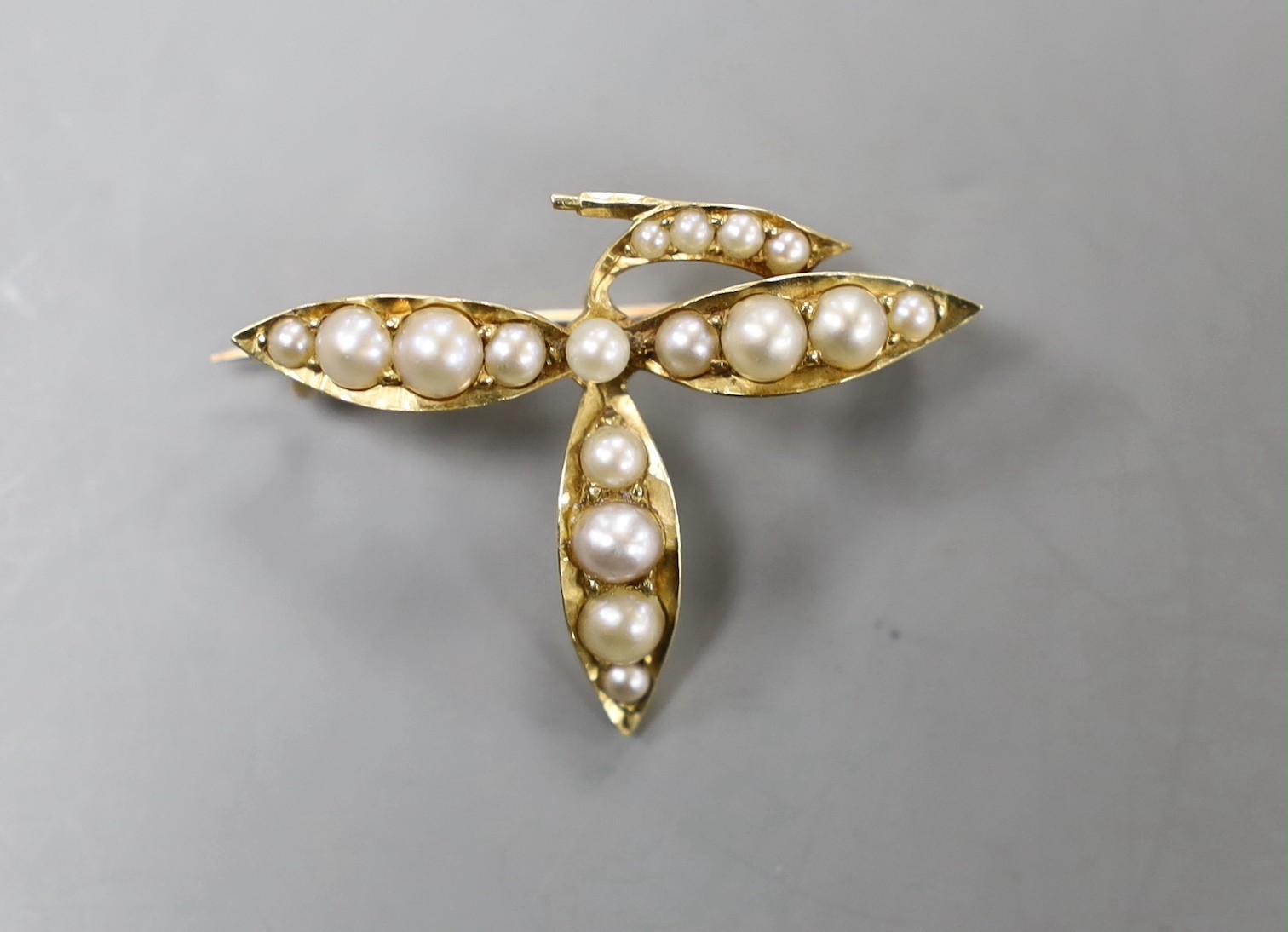 An early 20th century yellow metal and graduated seed pearl set leaf brooch, width 31mm, gross weight 3.2 grams.